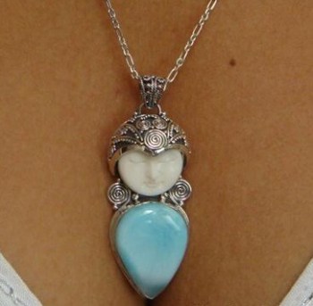 Zilveren hanger met gezicht uit been gesneden en Larimar druppel